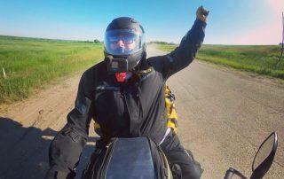 Noel Linsey of Epic Rides MB travelling down a gravel road on his motorcycle during a moto camping adventure in Manitoba.